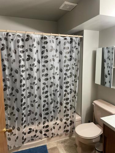 a bathroom with a black and white shower curtain at One Bedroom Main floor Apartment in Camrose