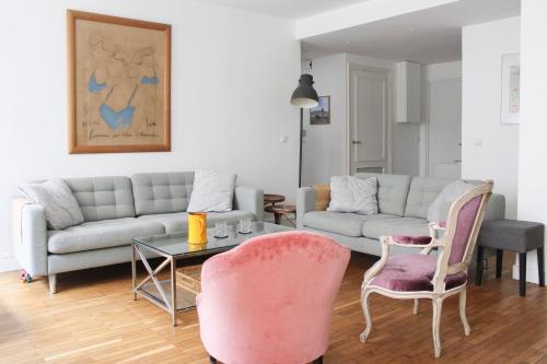 - un salon avec un canapé, une table et des chaises dans l'établissement Spacious cocoon 2 steps from the Eiffel Tower, à Paris