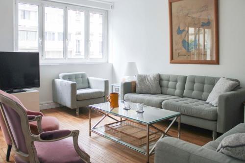 a living room with a couch and a table at Spacious cocoon 2 steps from the Eiffel Tower in Paris