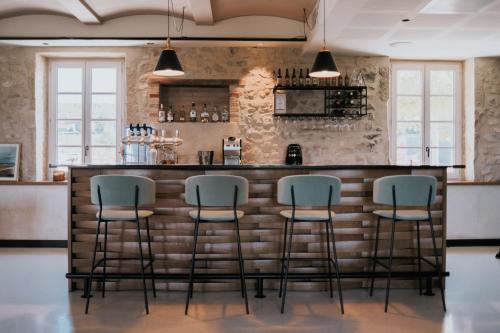 a bar with four stools in front of a brick wall at Garenne in Livron-sur-Drôme