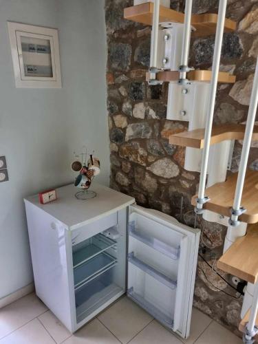 a room with a white desk and a stone wall at Οικοδέσποινα in Mytilini