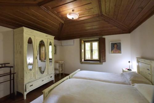 a bedroom with a large bed and a wooden ceiling at Casa da Ramada, Turismo Espaço rural. in Ponte de Lima
