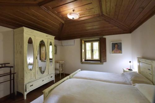 a bedroom with a large bed and a wooden ceiling at Casa da Ramada, Turismo Espaço rural. in Ponte de Lima