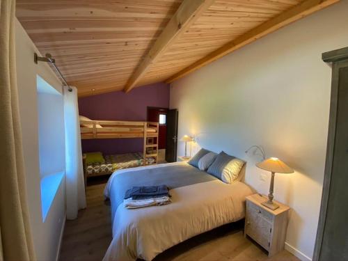 - une chambre avec un grand lit et un plafond en bois dans l'établissement Gite de charme au coeur des vignes, à Maisdon-sur-Sèvre