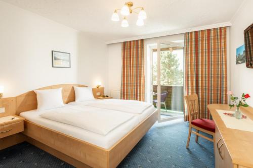 a bedroom with a large bed and a window at Landhotel Stofflerwirt in Sankt Michael im Lungau