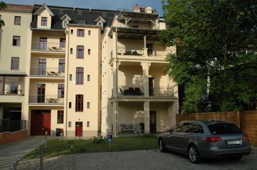 a car parked in front of a large building at Pension Alba in Görlitz
