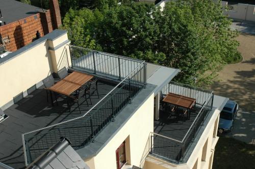 a balcony with tables and chairs on a building at Pension Alba in Görlitz