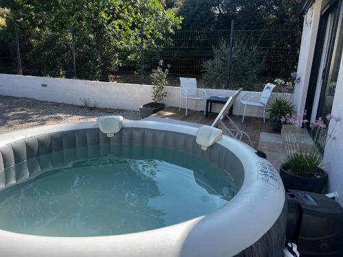 - un bain à remous dans la cour avec une table et des chaises dans l'établissement Maisonnette 32m2 climatisé avec jacuzzi au calme., à Trans-en-Provence