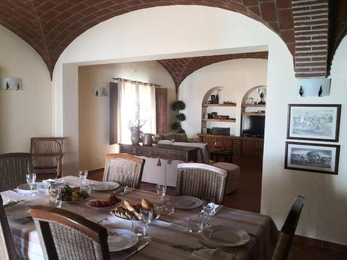 a dining room with a table and chairs with food on it at JOHN's Farm Country HOUSE in Montemor-o-Novo