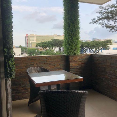 a table and two chairs sitting on a balcony at Hoteles en Guayaquil - Suites Guayaquil Cerca del Aeropuerto in Guayaquil