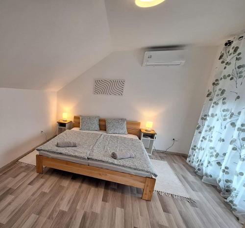 1 dormitorio con 1 cama y 2 lámparas en 2 mesas en Lake27apartman, en Szántód