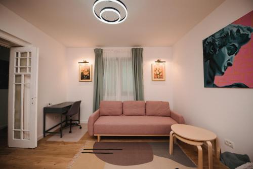 sala de estar con sofá rosa y piano en Cotroceni Accommodations, en Bucarest