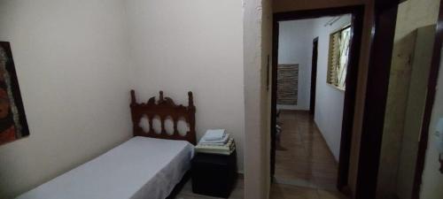 a small bedroom with a bed and a hallway at Casa de Boneca aconchegante in Uberaba