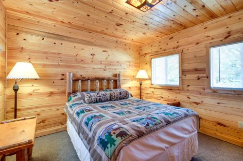 1 dormitorio con 1 cama en una cabaña de madera en Walleye Cabin on Mille Lacs Lake Boat and Fish!, en Garrison