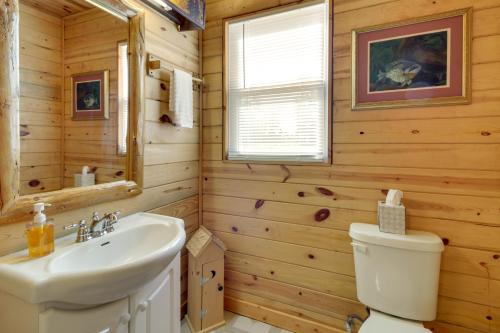 een badkamer met een wastafel, een toilet en een raam bij Walleye Cabin on Mille Lacs Lake Boat and Fish! in Garrison