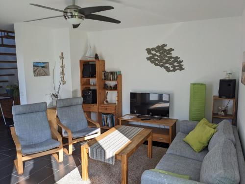 a living room with a couch and chairs and a tv at Ferienwohnung Pappelwende in Ostseebad Karlshagen