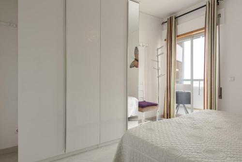 a white room with a bed and a window at Horizonte - Sea view by HD PROPERTIES in Quarteira