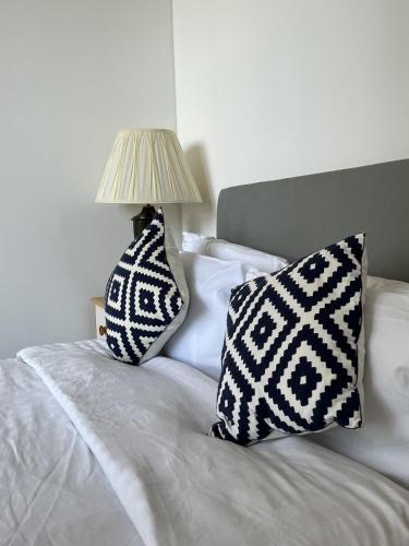 a bed with two pillows and a lamp on it at Ensuite Double Room, by Swansea University, Sketty, R2 in Swansea