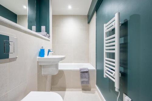 uma casa de banho com um lavatório, um WC e uma banheira em Stunning 2BD Apartment in Manchester em Manchester
