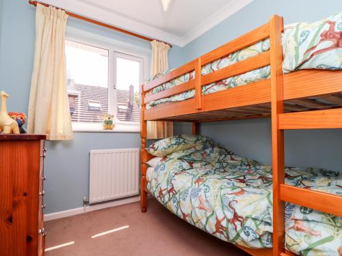 a bedroom with two bunk beds and a window at Dragonflies & Seahorses in Falmouth