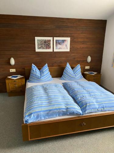 a large bed with blue pillows in a bedroom at Gästehaus Hochwimmer in Hollersbach im Pinzgau