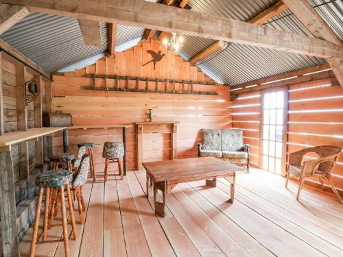 a room with a table and chairs in a cabin at Y Caban in Llangollen