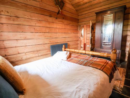 a bedroom with a bed in a wooden cabin at Y Caban in Llangollen