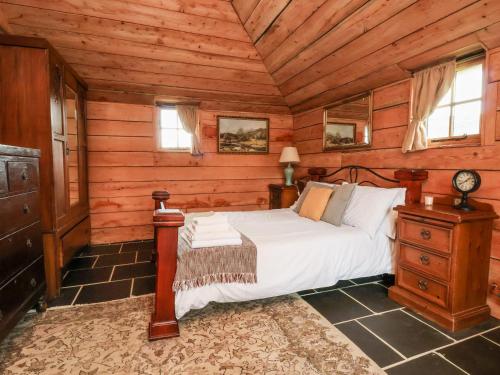 a bedroom with a bed in a wooden cabin at Y Caban in Llangollen