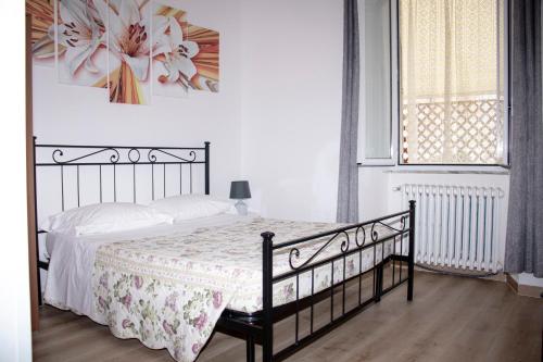 a bedroom with a bed with a floral bedspread and a window at B&B Villa Susanna in Civitavecchia