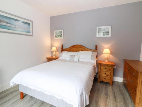een slaapkamer met een wit bed en 2 nachtkastjes bij 17 Clover Hill in Killorglin