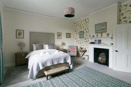 a bedroom with a bed and a fireplace at Stay On The Hill - The Coach House in Hexham
