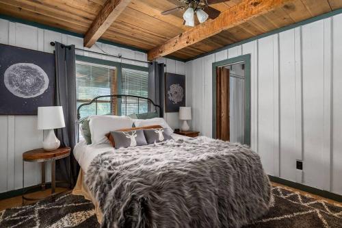 um quarto com uma cama e uma ventoinha de tecto em Rustic Cabin, Dock, Firepit, Kayaks & Games em Winchester