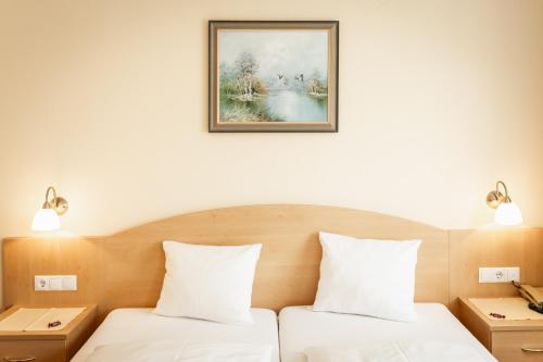 a bedroom with two beds and a picture on the wall at Landhotel Stofflerwirt in Sankt Michael im Lungau