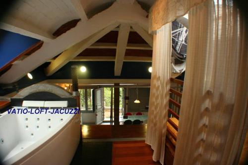a large room with a vaulted ceiling and a staircase at zentralclub apartamento vatio- jacuzzi in Belmonte de Miranda