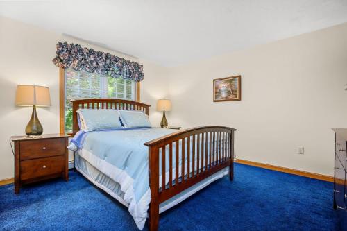 a bedroom with a wooden bed and a window at 20 Victoria Lane Dennis Cape Cod - 5 O'Clock Somewhere in Dennis
