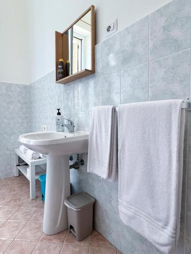 a bathroom with a sink and a mirror and towels at Villa Susanna in Civitavecchia