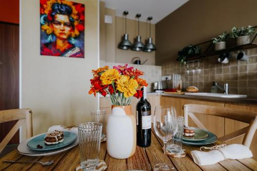 een tafel met een fles wijn en bloemen erop bij Apartament Miasto i Wisła in Sandomierz