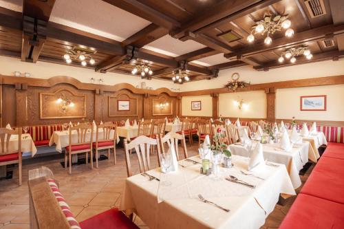 a dining room with white tables and chairs at Landhotel Stofflerwirt in Sankt Michael im Lungau