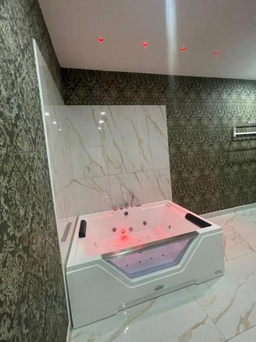 Life Hotel في كازالنووفو دي نابولي: حمام مع حوض استحمام مع إضاءة وردية