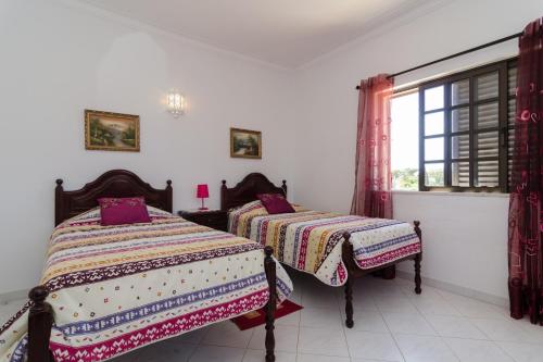a bedroom with two beds and a window at Villa with Private Pool Near Benagil & Marinha Beach in Lagoa