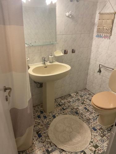 La salle de bains est pourvue d'un lavabo et de toilettes. dans l'établissement Floros Apartments, à Agios Stefanos
