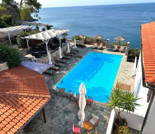 a swimming pool with the ocean in the background at Yalis Hotel in Votsi