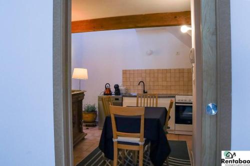 une cuisine avec une table et des chaises dans une pièce dans l'établissement Maison de ville, à Avignon