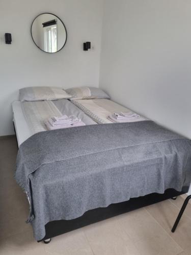 a bed with a gray blanket and a mirror at Hvammur 6 with private hot tub 