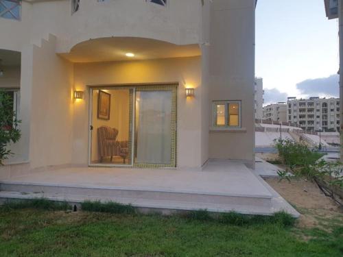 un porche delantero de una casa con una puerta corredera de cristal en Stella highets, en El Alamein