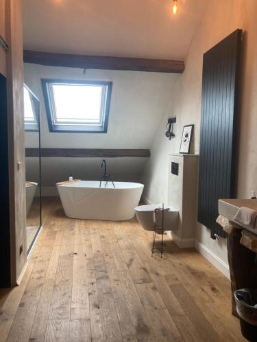 a large bathroom with a tub and two sinks at Monsieur Doute in Durbuy