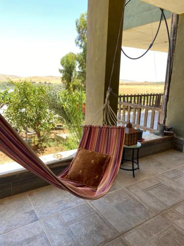 a hammock on a porch with a view of the desert at Simple home in Madaba
