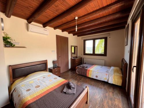 1 dormitorio con 2 camas y ventana en Valencia Grove Villa en Miliou