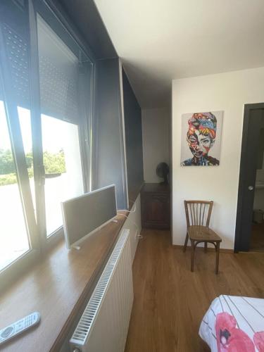 a bedroom with a desk with a computer and a chair at Ar-Gavotenn in Le Saint