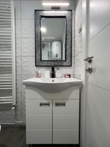 un bagno con un lavandino bianco e uno specchio di Apartman Jovana 2 a Sremska Mitrovica